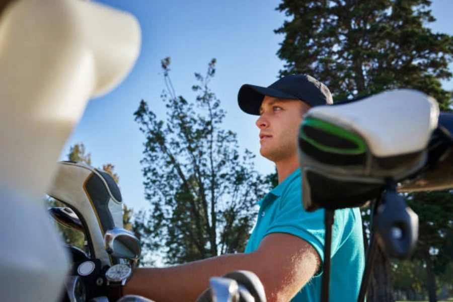 Man with golf bag and leather golf club head covers