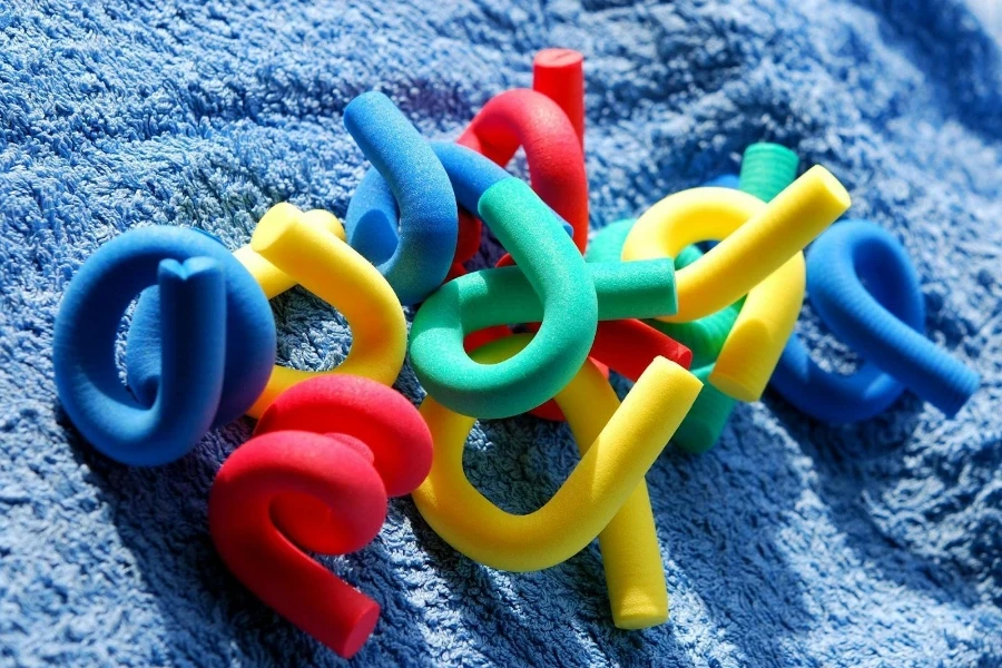 Multi-colored flexi-rod hair rollers on a blue, textured background