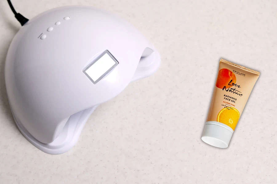 Nail lamp and sunscreen on a white background