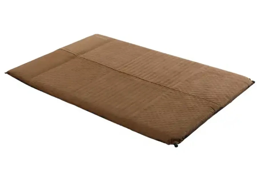 One brown deflated self-inflating camping mattress