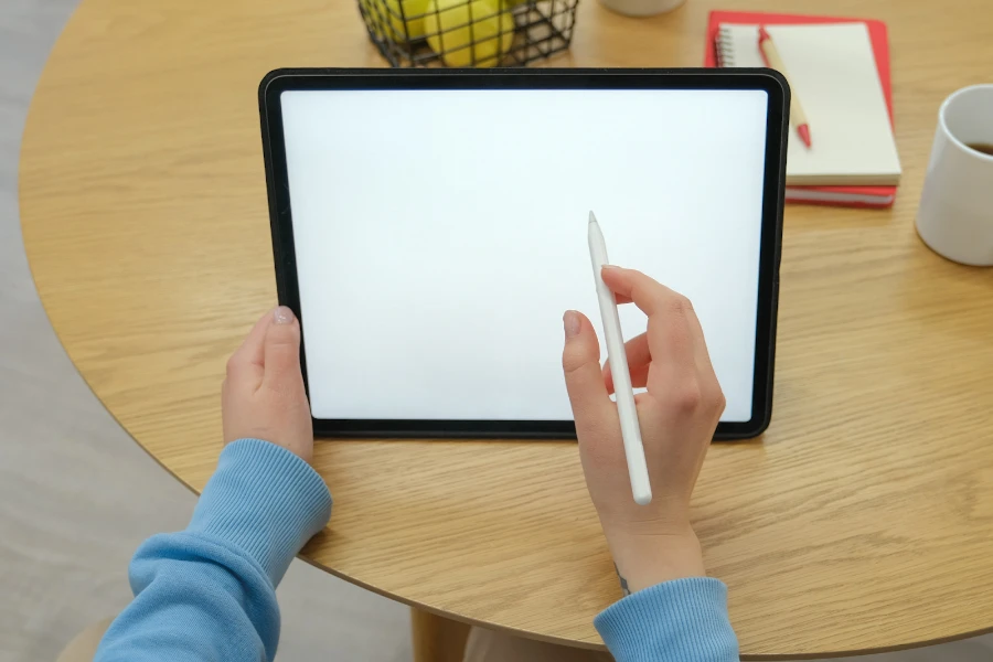 Person getting ready to use a stylus pen on a tablet