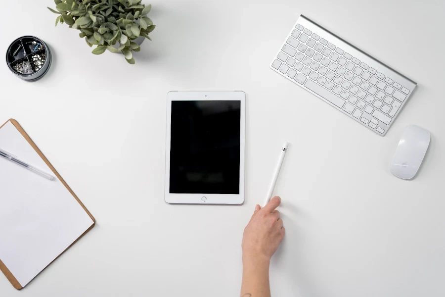 Person holding a white stylus pen on a table