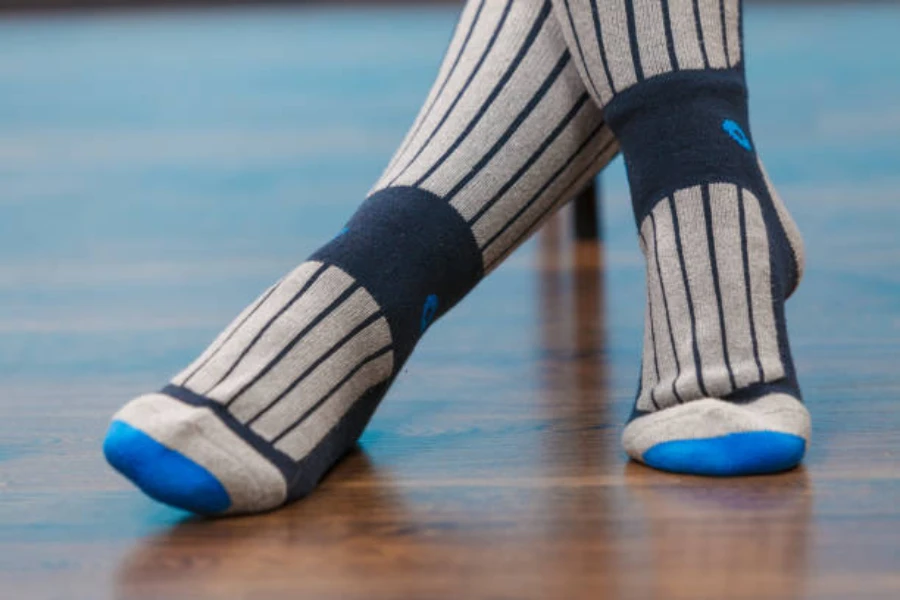 Person wearing padded socks for cheerleading on wooden floor