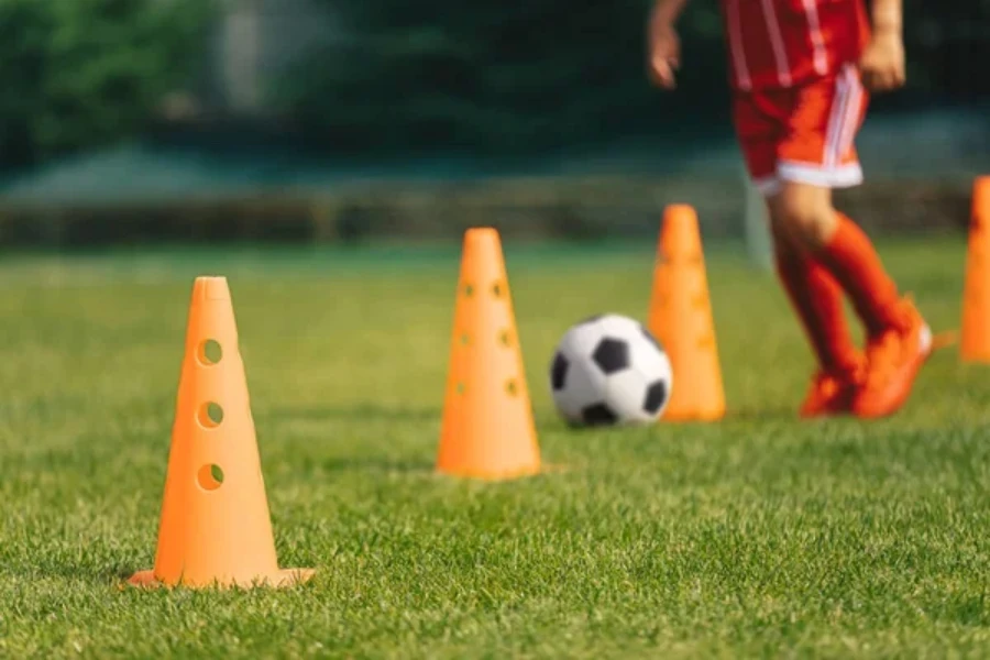 Jogador praticando com vários cones laranja