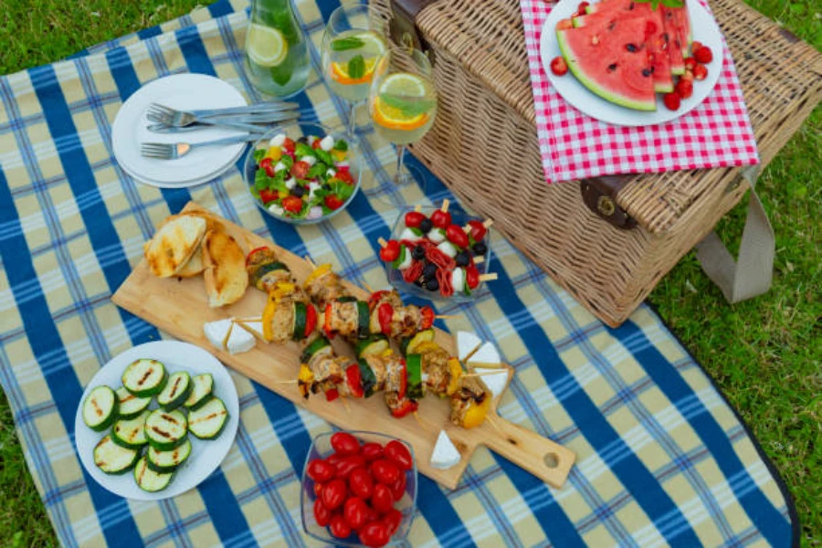 Selection of food laid out on blue picnic mat