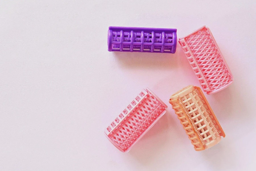 Several colored velcro hair rollers on a gray background