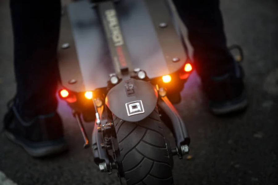 Pequeñas luces rojas en la parte trasera de un scooter eléctrico.