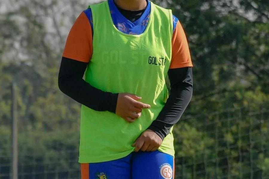 Smiling female soccer player in a green pinnie