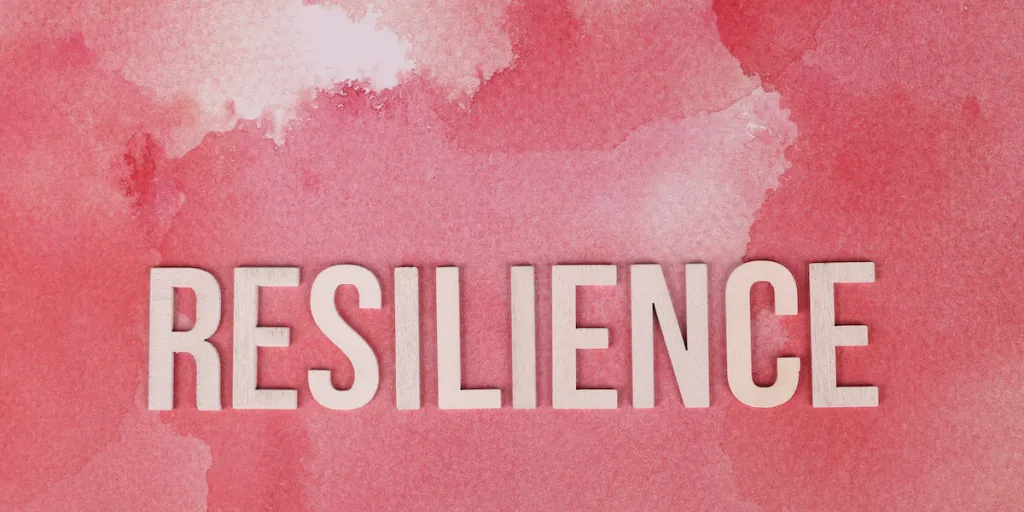 the word resilience on a pink surface