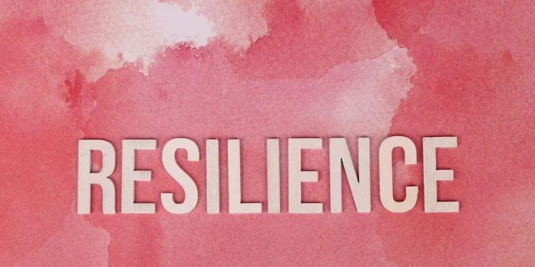 the word resilience on a pink surface