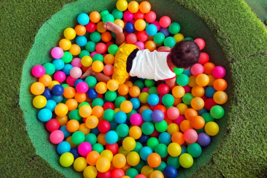 Toddler playing inside small rounded ball pit with colorful balls