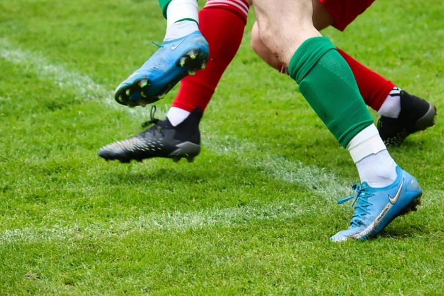 Two players on a field wearing cleats