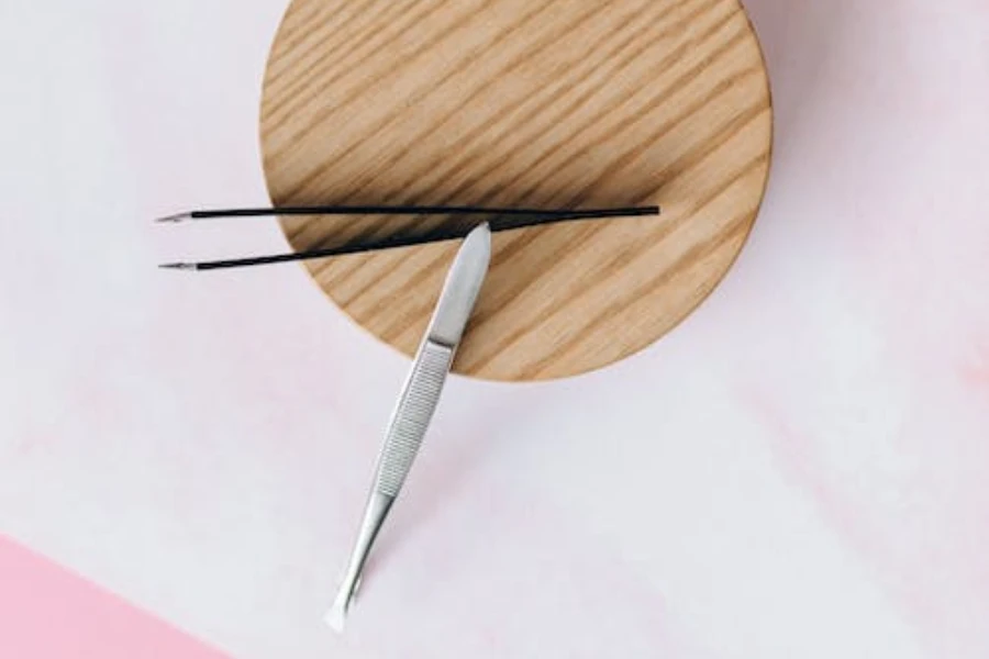 Two tweezers on a circular wooden surface