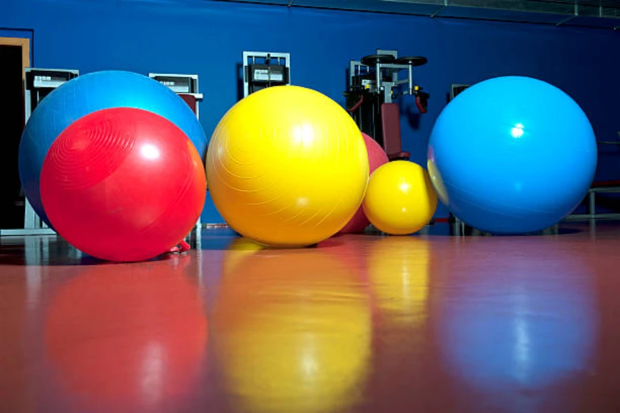 Various colors of different sized exercise balls in a gym