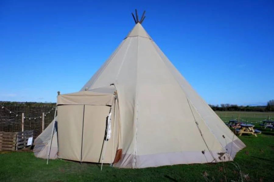 White inflatable yurt tent set in a field with benches