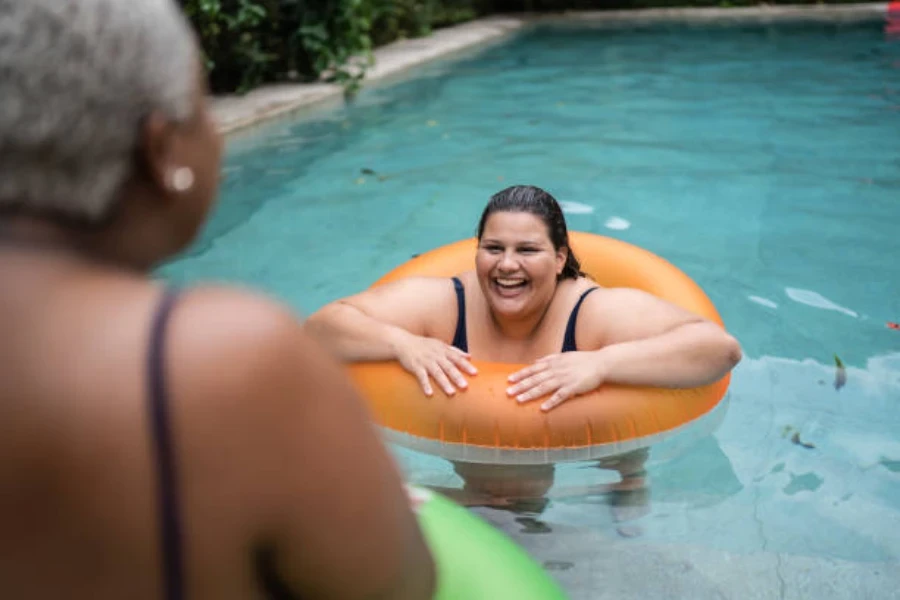 Mulher flutuando na piscina com anel de natação laranja