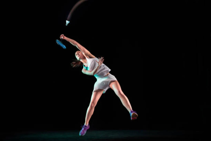 Woman hitting a mash using a head heavy badminton racket