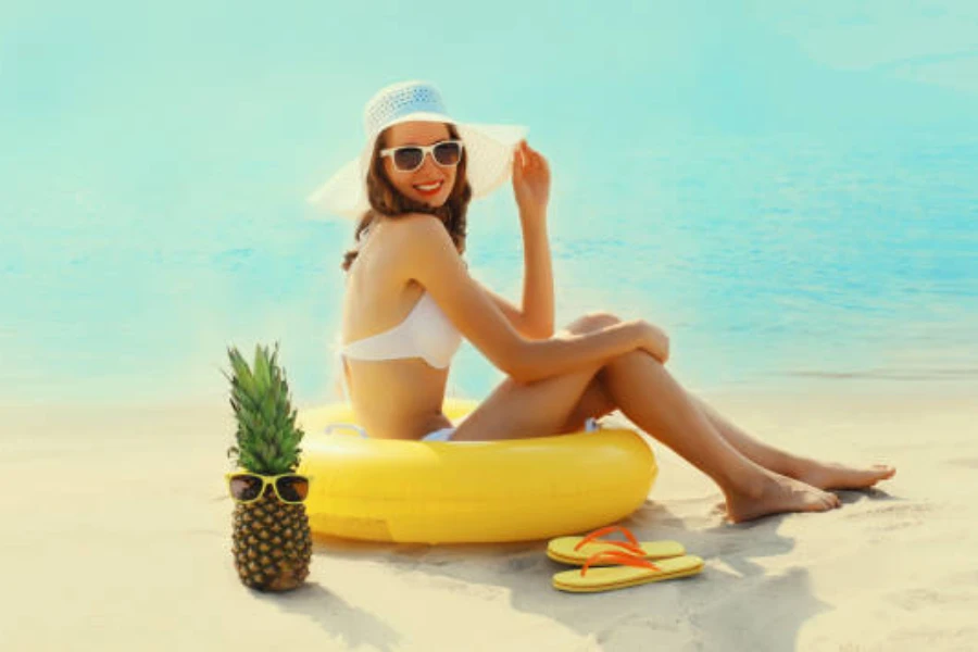 Woman sitting on beach inside a yellow swimming ring