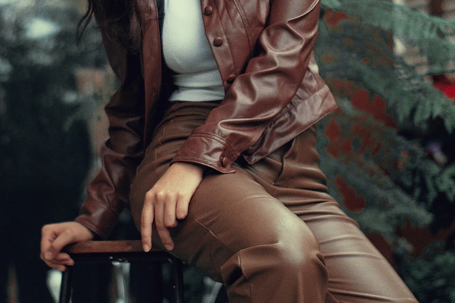 Woman sitting on chair wearing brown leather pants