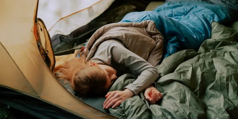 Woman sleeping in a tent on a camping mattress