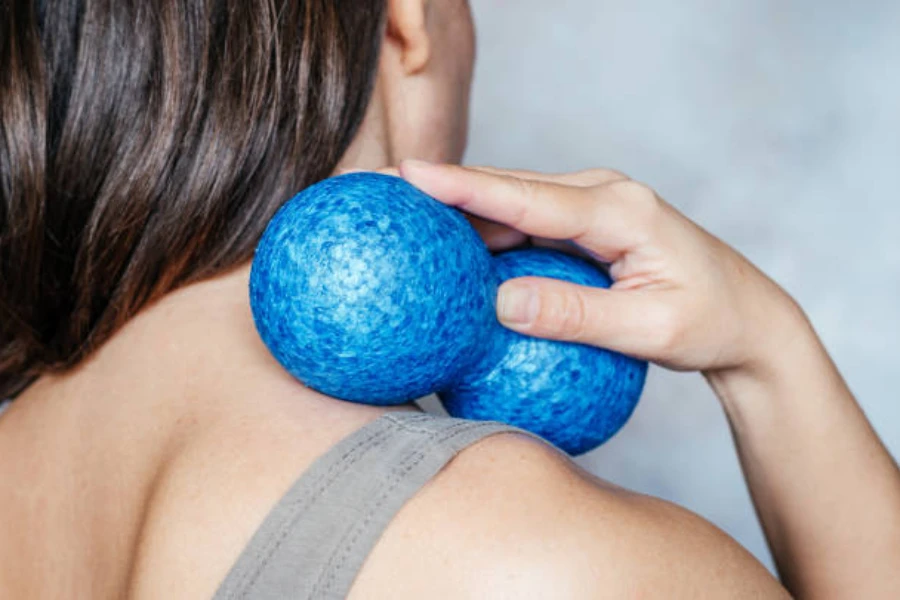Woman using blue peanut massage ball on her neck