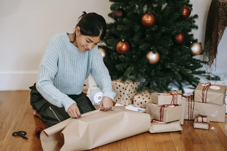 Femme utilisant du papier d'emballage cadeau marron