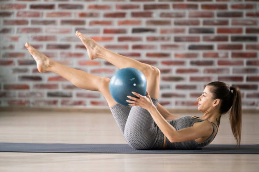 Woman using small blue balance ball for core workout