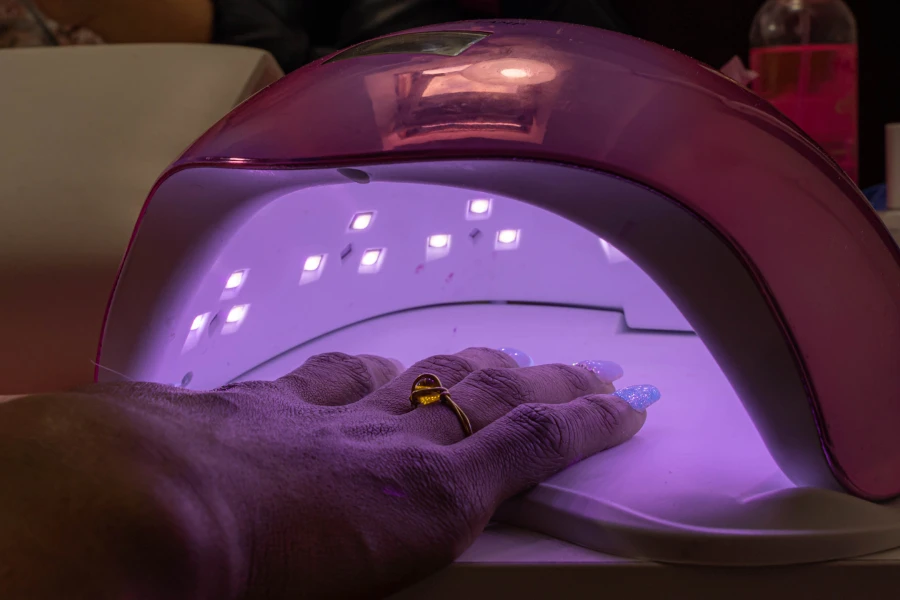 Woman's painted nails inside a nail lamp