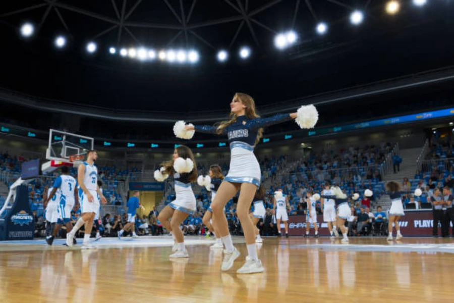 Women in cheerleading square performing routine at basketball game