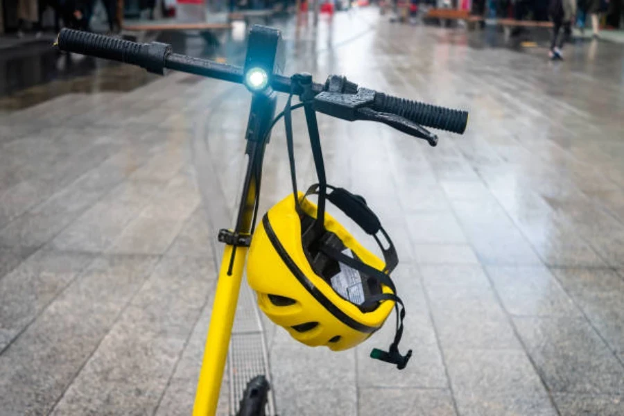 Patinete eléctrico amarillo con luz y casco amarillo a juego.