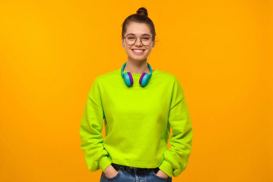 Junges glückliches Mädchen im grünen Neon-Sweatshirt
