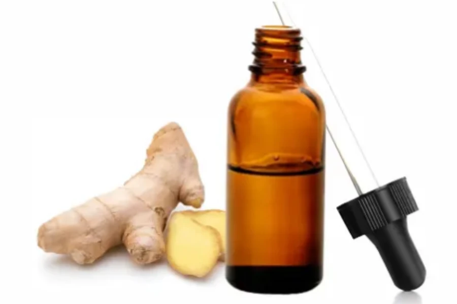 A bottle of ginger essential oil and ginger beside it
