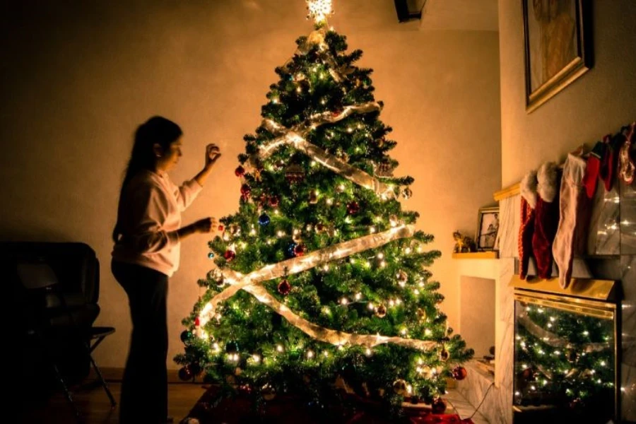 Un enfant debout devant un sapin de Noël