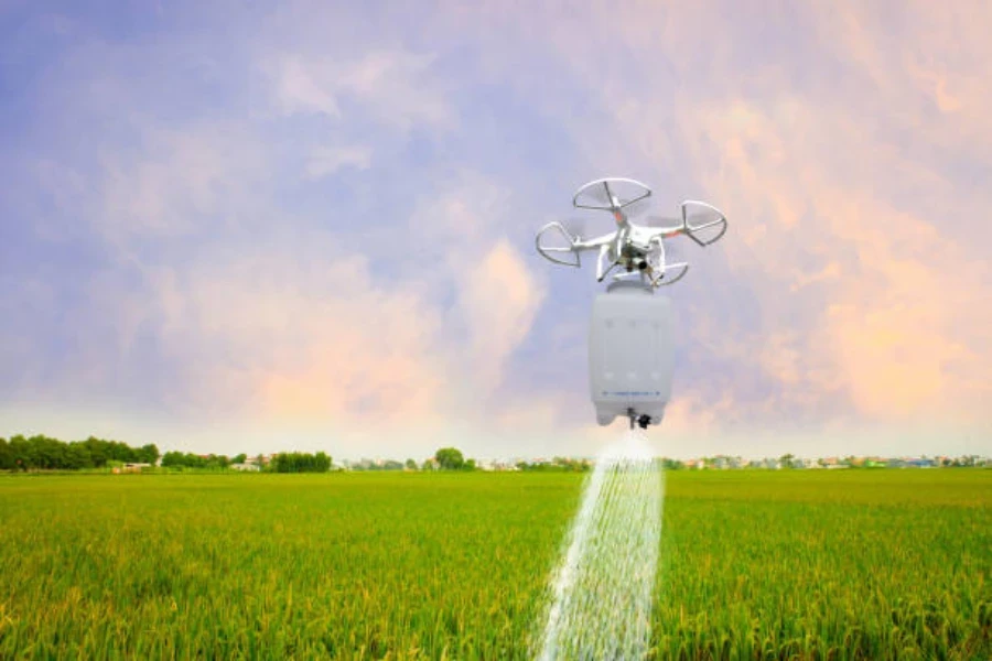 Un dron en vuelo rociando insecticida en un campo de arroz