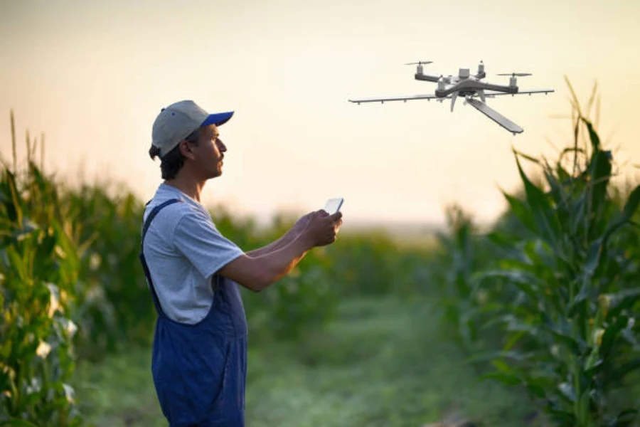 Un agricoltore che irrora i suoi raccolti usando un drone irroratore