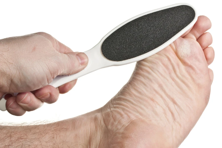 A foot file being used on callused feet