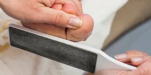 A foot file being used on callused feet