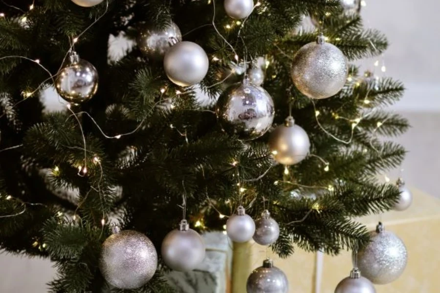 Un árbol de Navidad verde con adornos plateados.