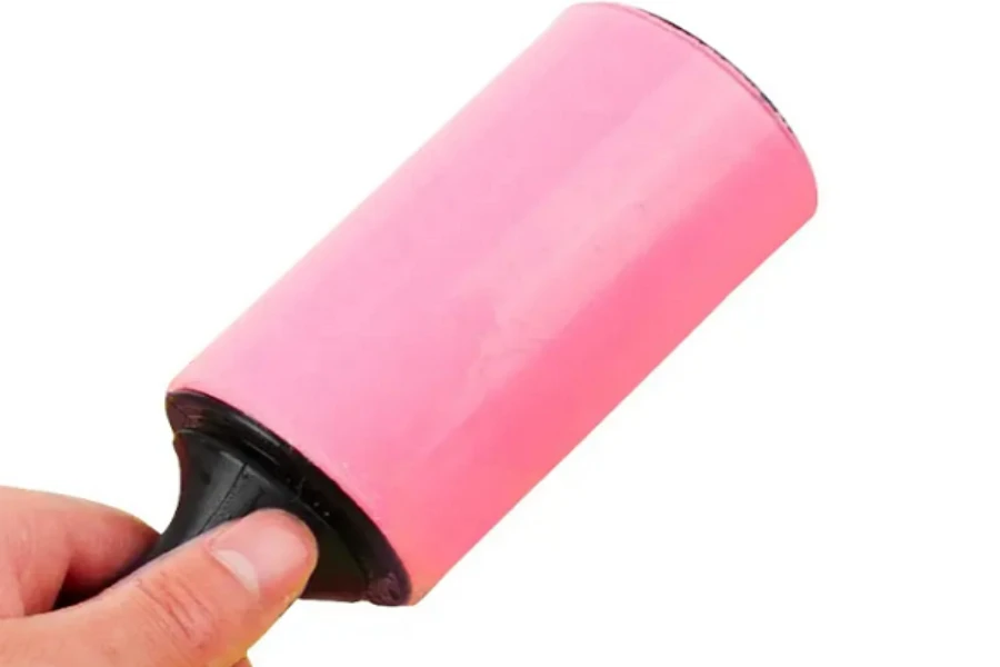 A hand holding a reusable lint roller