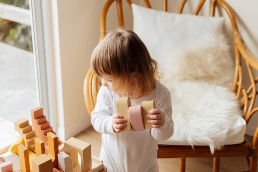 A little girl playing with wooden building blocks