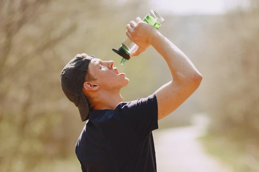 un homme buvant dans une bouteille de sport