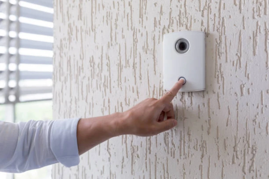 A man ringing a white smart doorbell