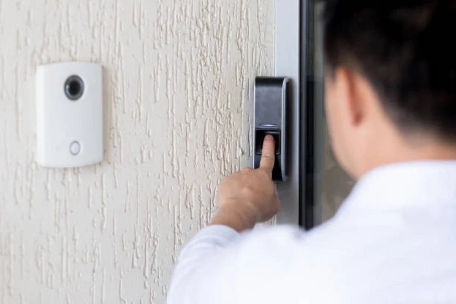 Un hombre usando una cerradura inteligente junto a un timbre inteligente