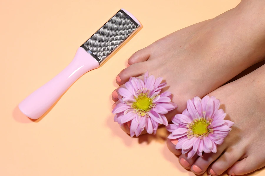 A manual callus remover with stainless steel beside treated feet