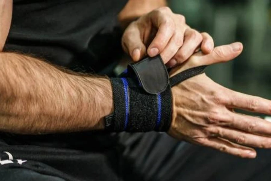 um homem de meia idade ajustando sua pulseira de levantamento de peso