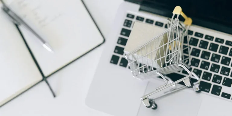a miniature shopping cart on macbook laptop