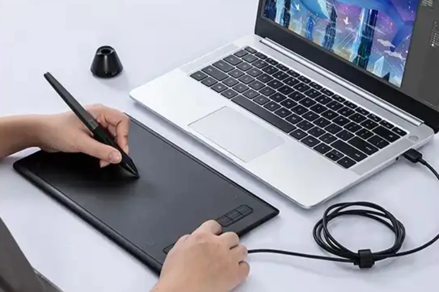 A person using a non-display drawing tablet connected to a laptop