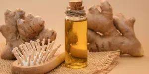 a photo of a glass bottle of essential ginger oil and ginger root