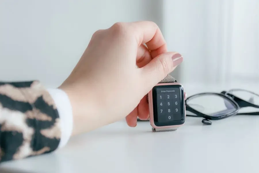 A rose gold smartwatch on a white surface