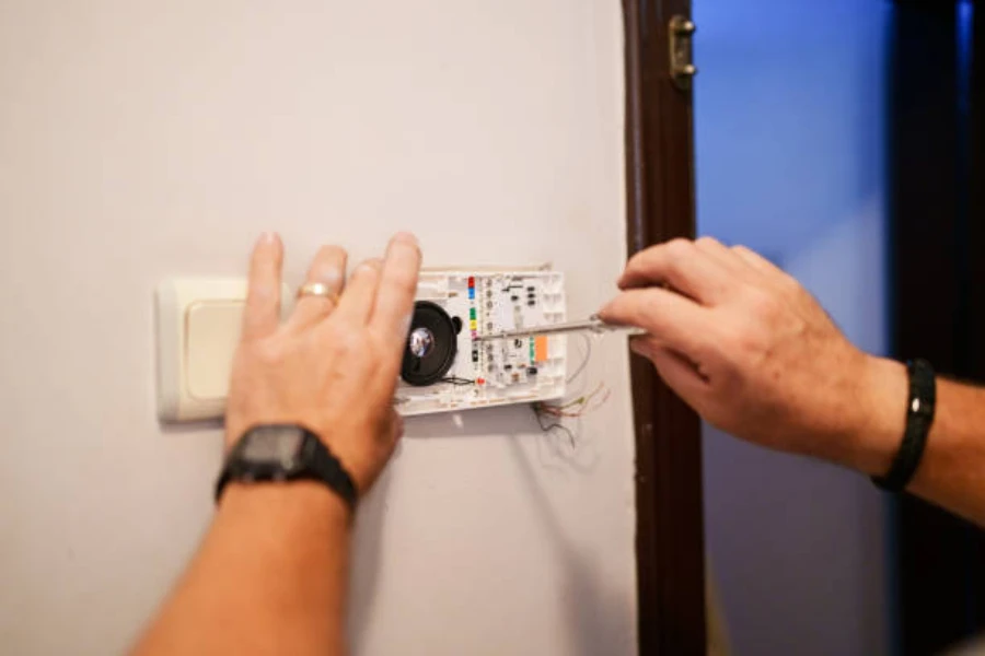 A technician installing a smart doorbell